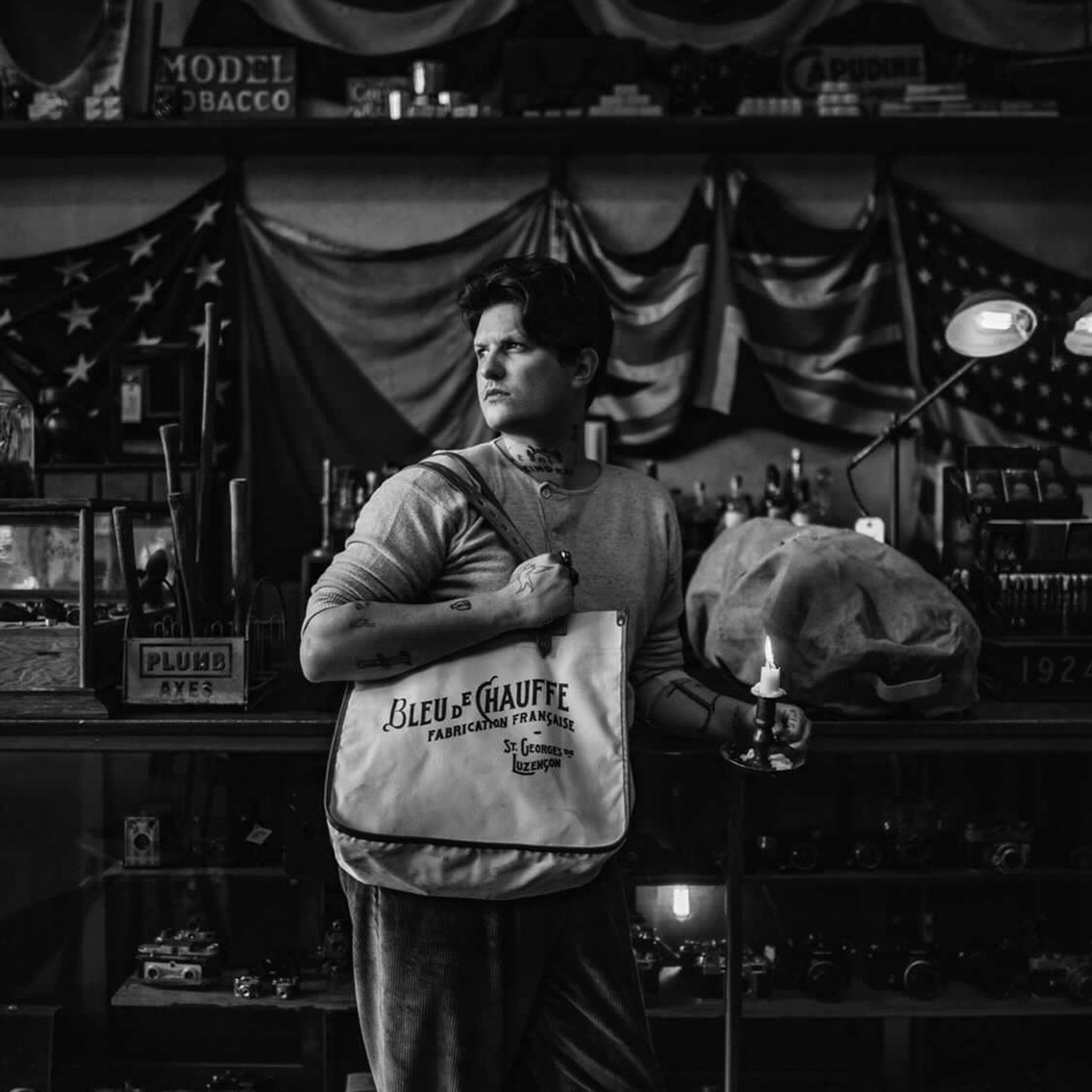 Un homme porte un cabas &agrave; l'&eacute;paule devant un comptoir
