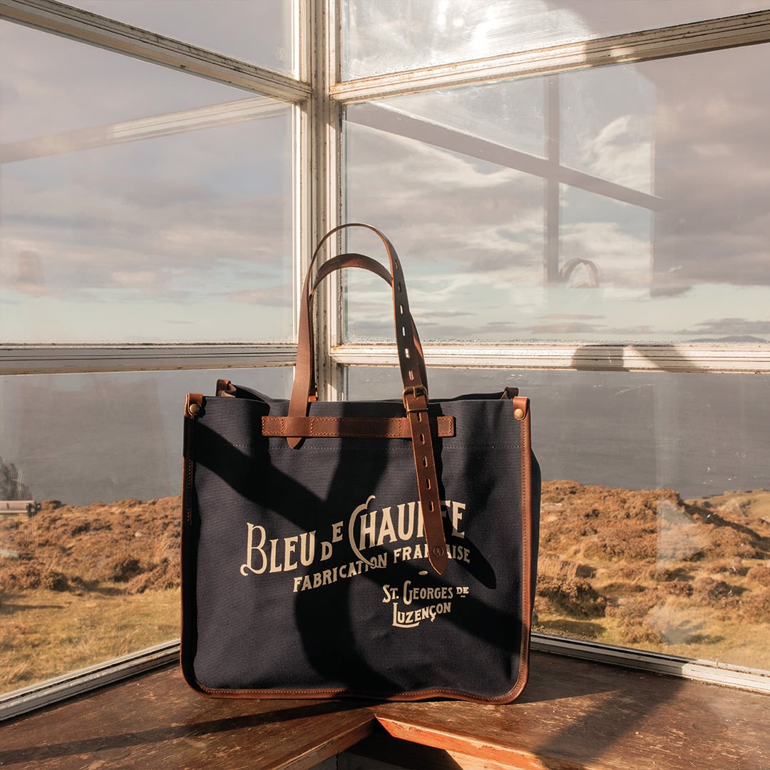 Sac cabas pos&eacute; devant une baie vitr&eacute;e avec vue sur la mer