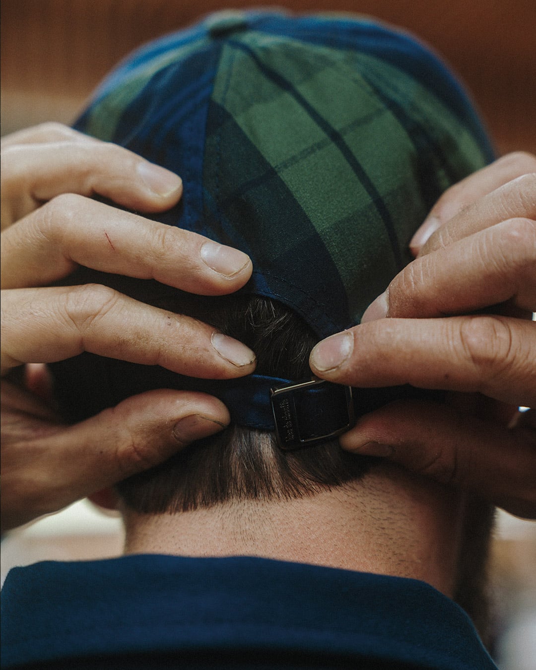Un homme regle sa casquette Gaspard grace a la boucle de serrage