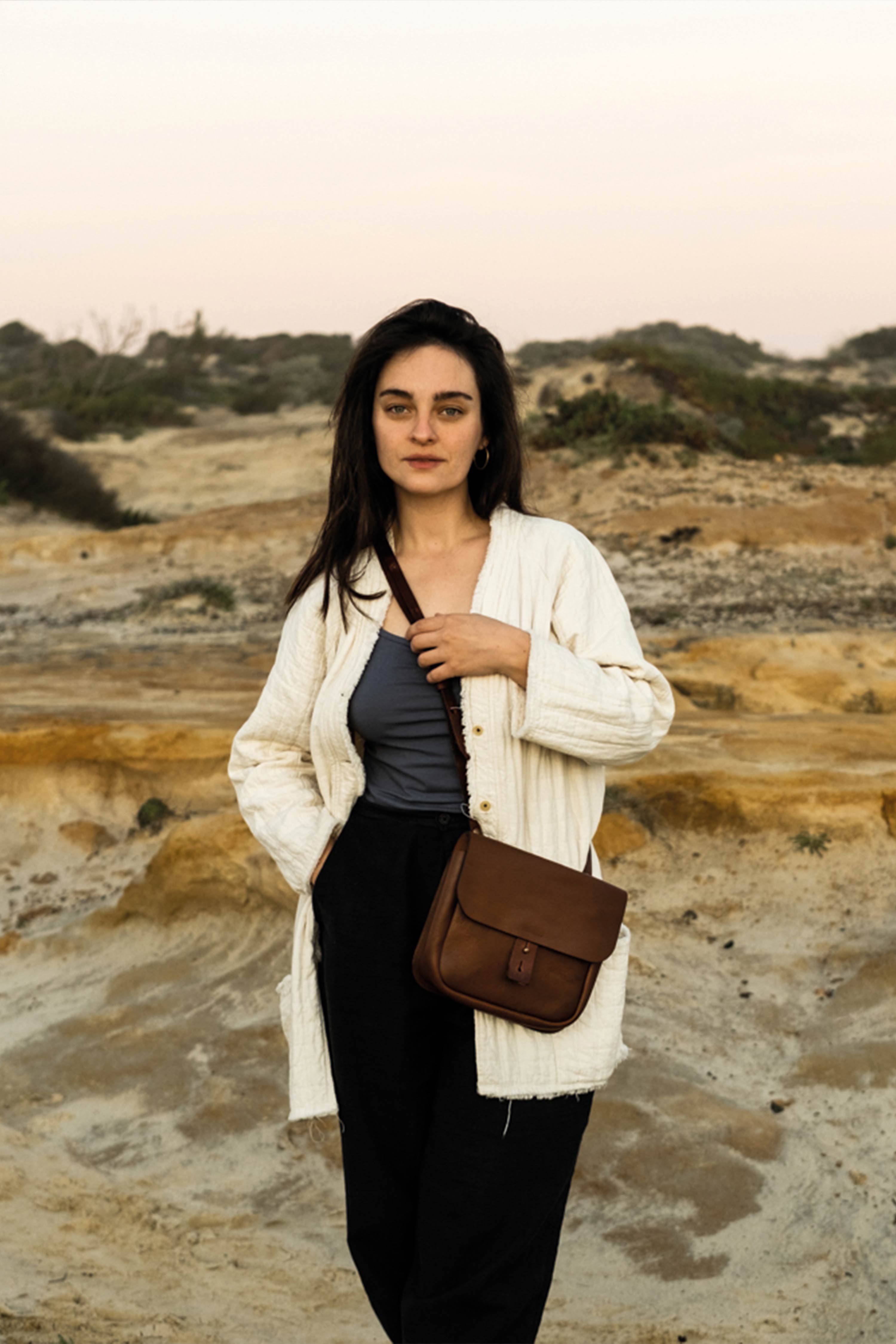 Une femme porte en bandouliere une sacoche en cuir nettoy&eacute;e