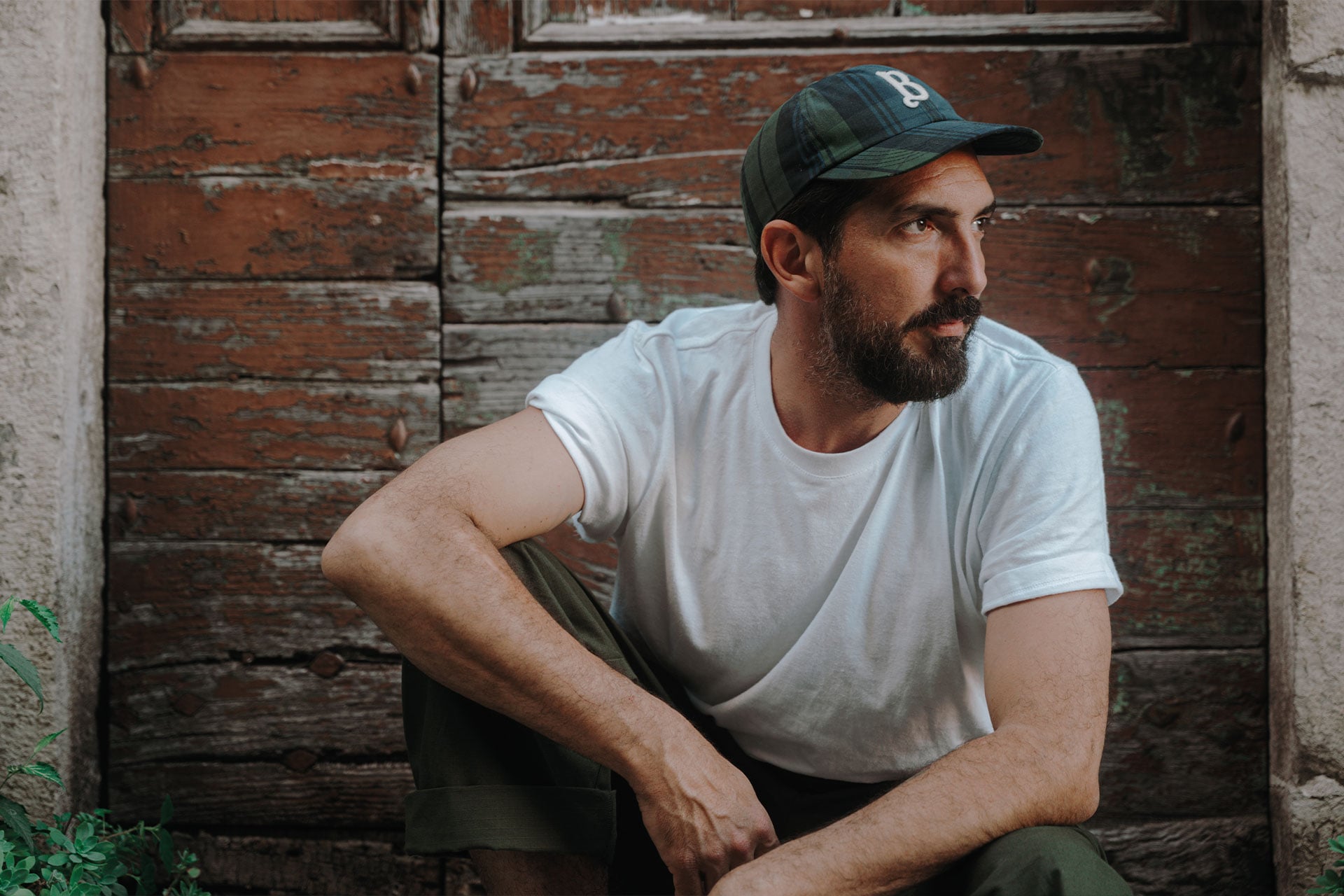 A man is wearing the French HWC t-shirt and the Gaspard cap by Bleu de Chauffe