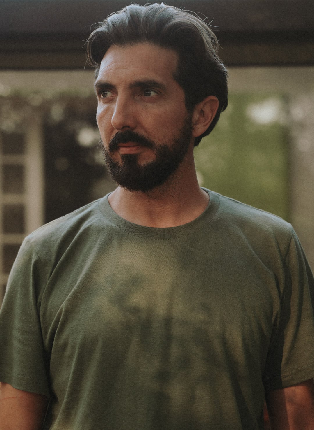 A man is wearing the lightweight khaki t-shirt by Bleu de Chauffe