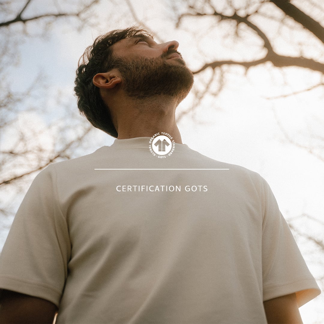 Un homme regarde vers le ciel, il porte un t-shirt blanc made in france