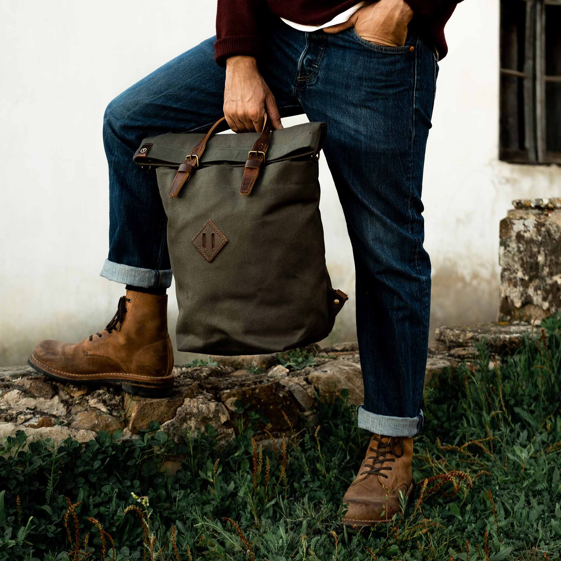 La mochila de lona Woody llevada por sus asas.