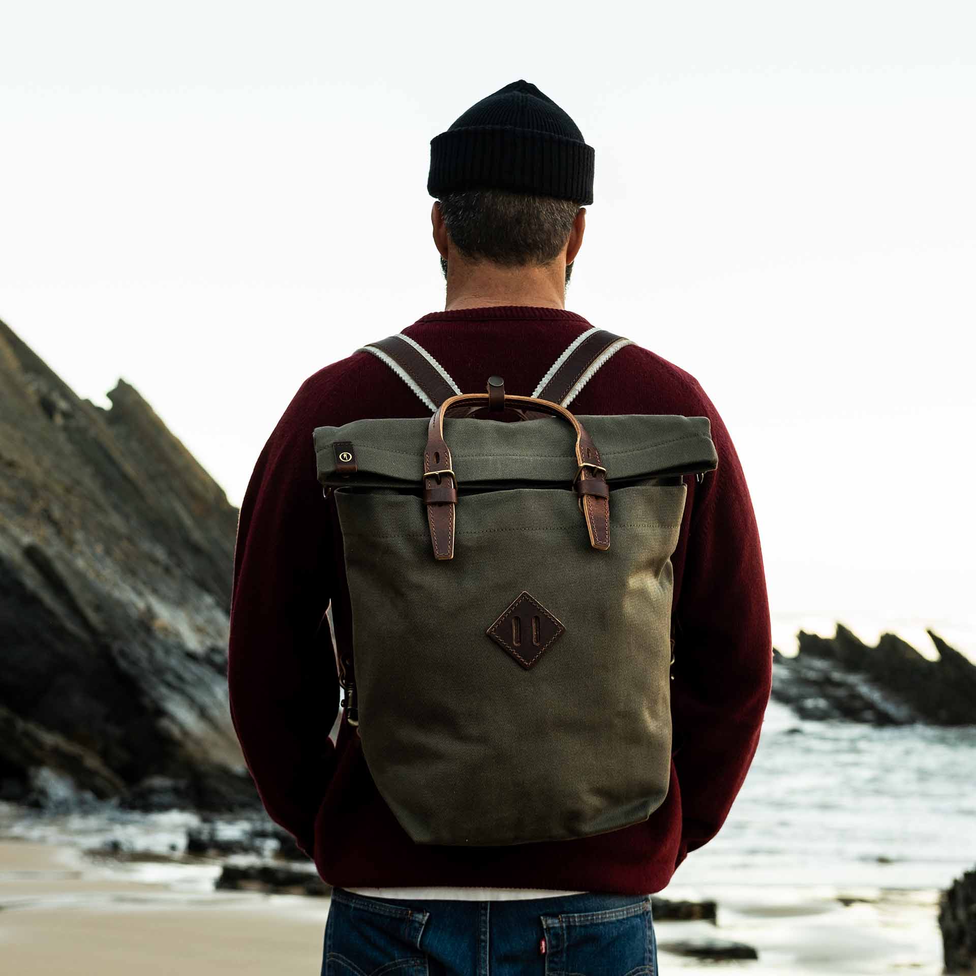 Un hombre lleva la mochila Woody en la playa.