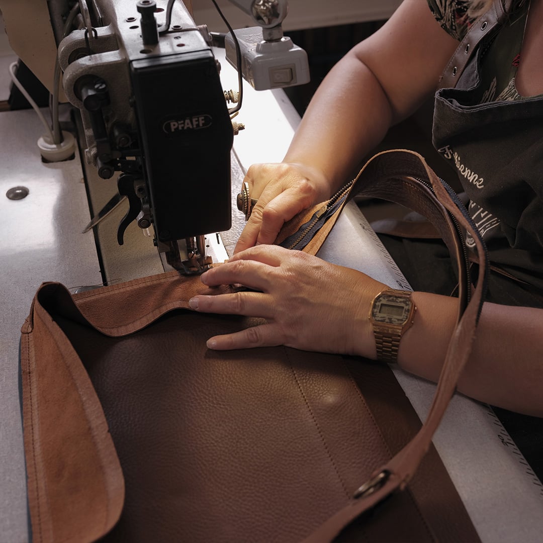 Un artesano de Bleu de Chauffe montando un bolso.
