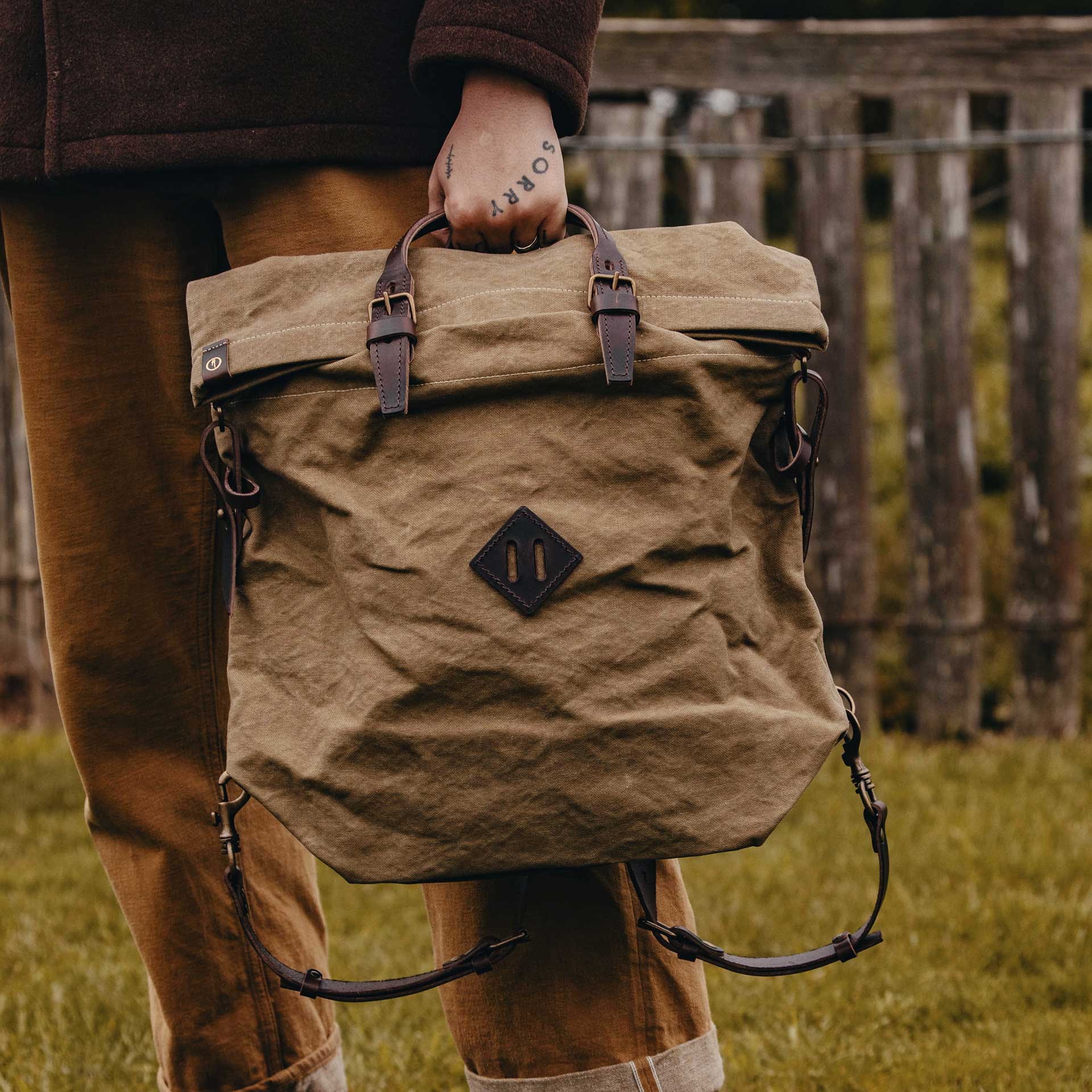 Ein Mann in der Natur tr&auml;gt einen Workwear-Rucksack.