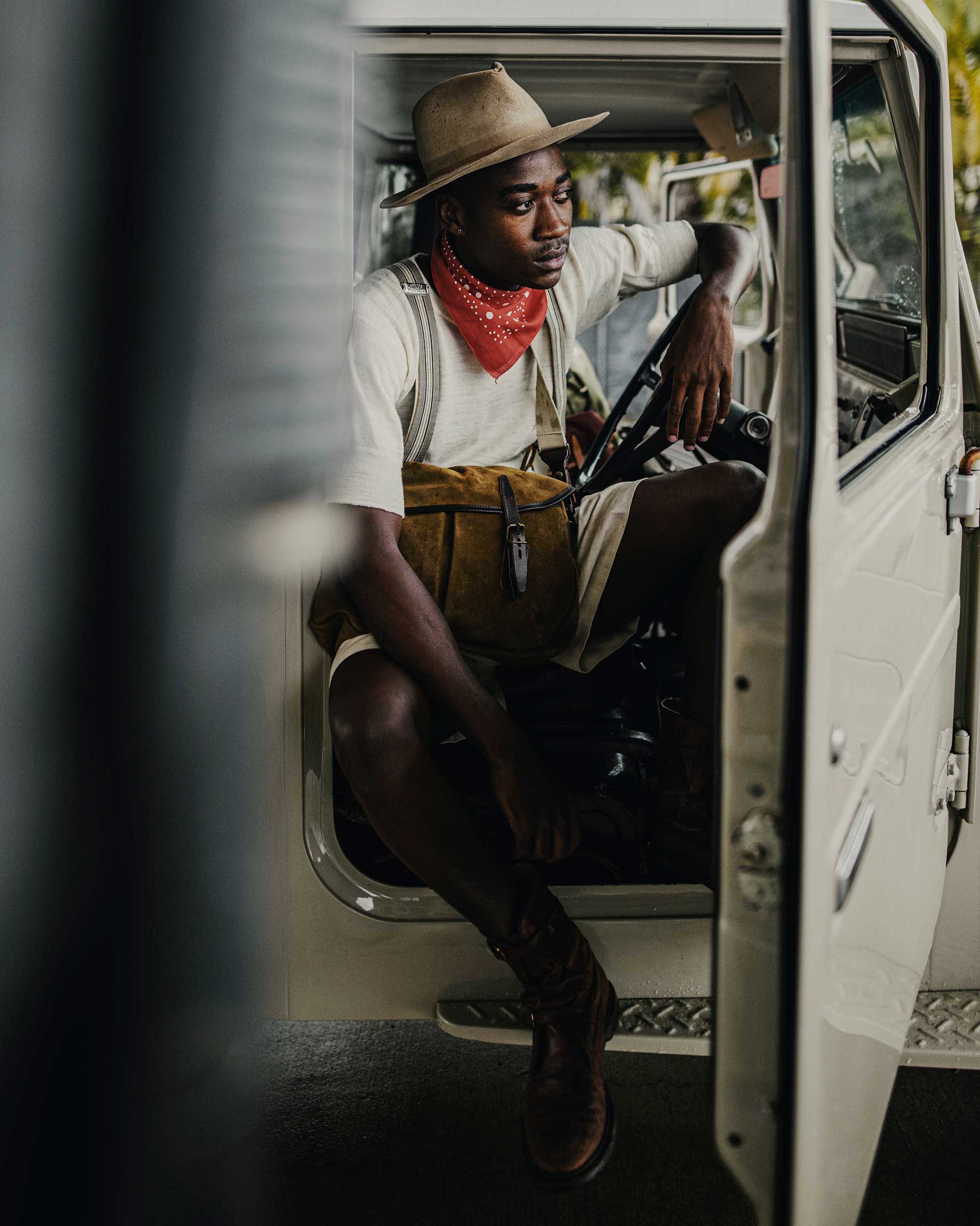 ein Mann, der in einem Jeep sitzt, tr&auml;gt eine Basis aus Veloursleder