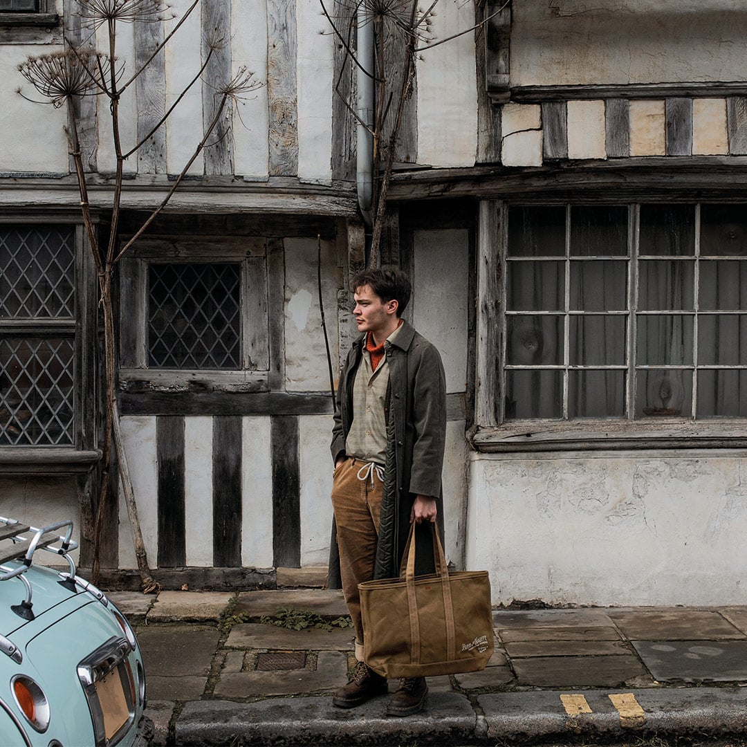 Un homme en tenue workwear porte le cabas Labor day en coloris camel