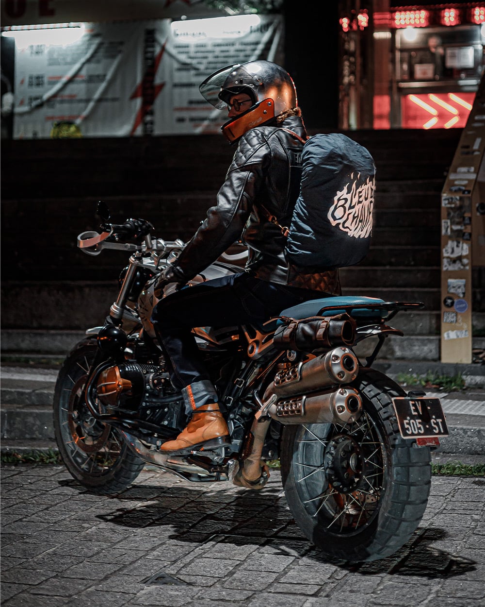 Homme a moto qui porte un sac a dos avec la housse de pluie Bleu de Chauffe