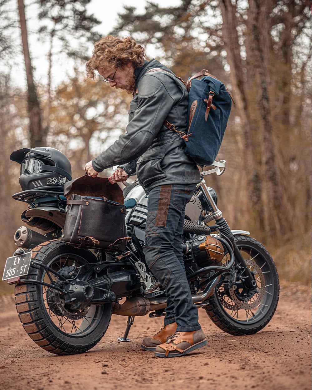 Homme qui ouvre son sac moto en cuir