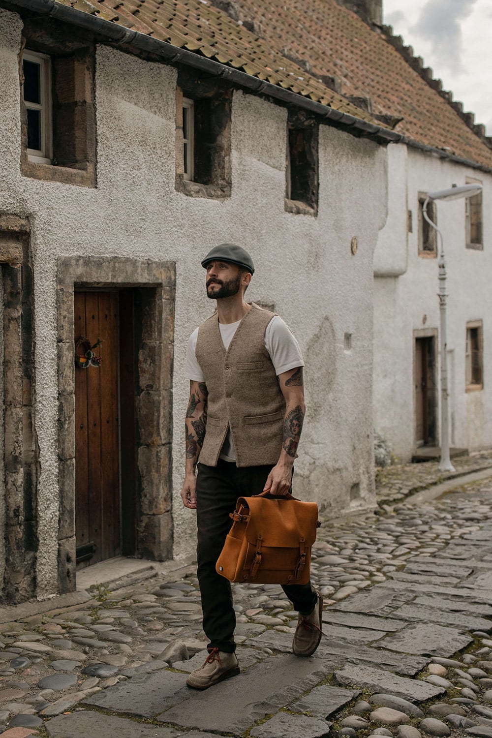 Un hombre lleva una cartera de cuero en un pueblo. 