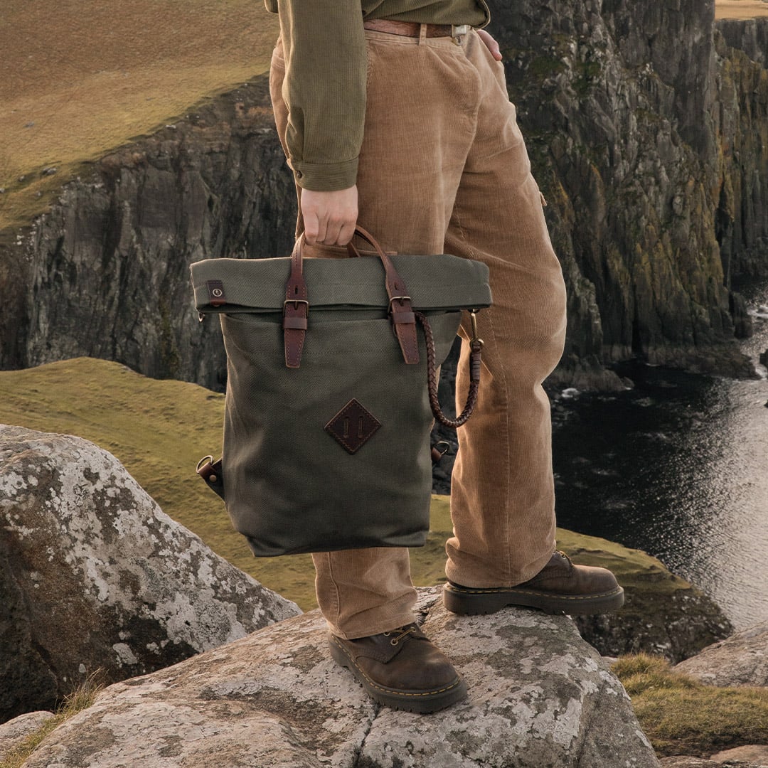 Une personne porte par la anse le sac &agrave; dos en toile Woody