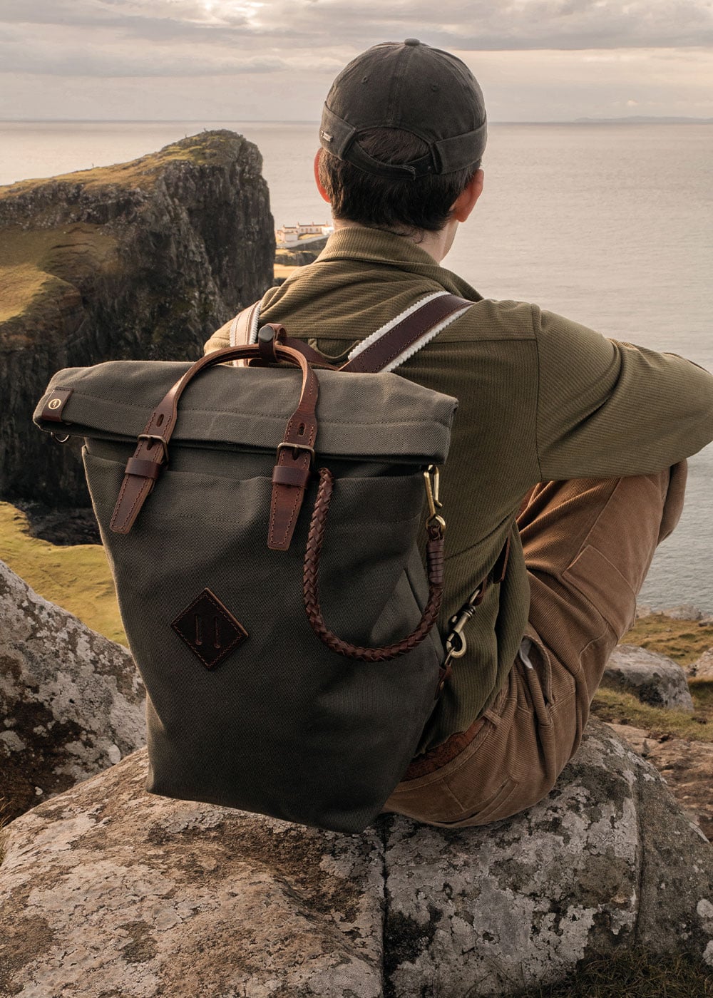 Au bord d'une falaise un homme porte le sac a dos Woody