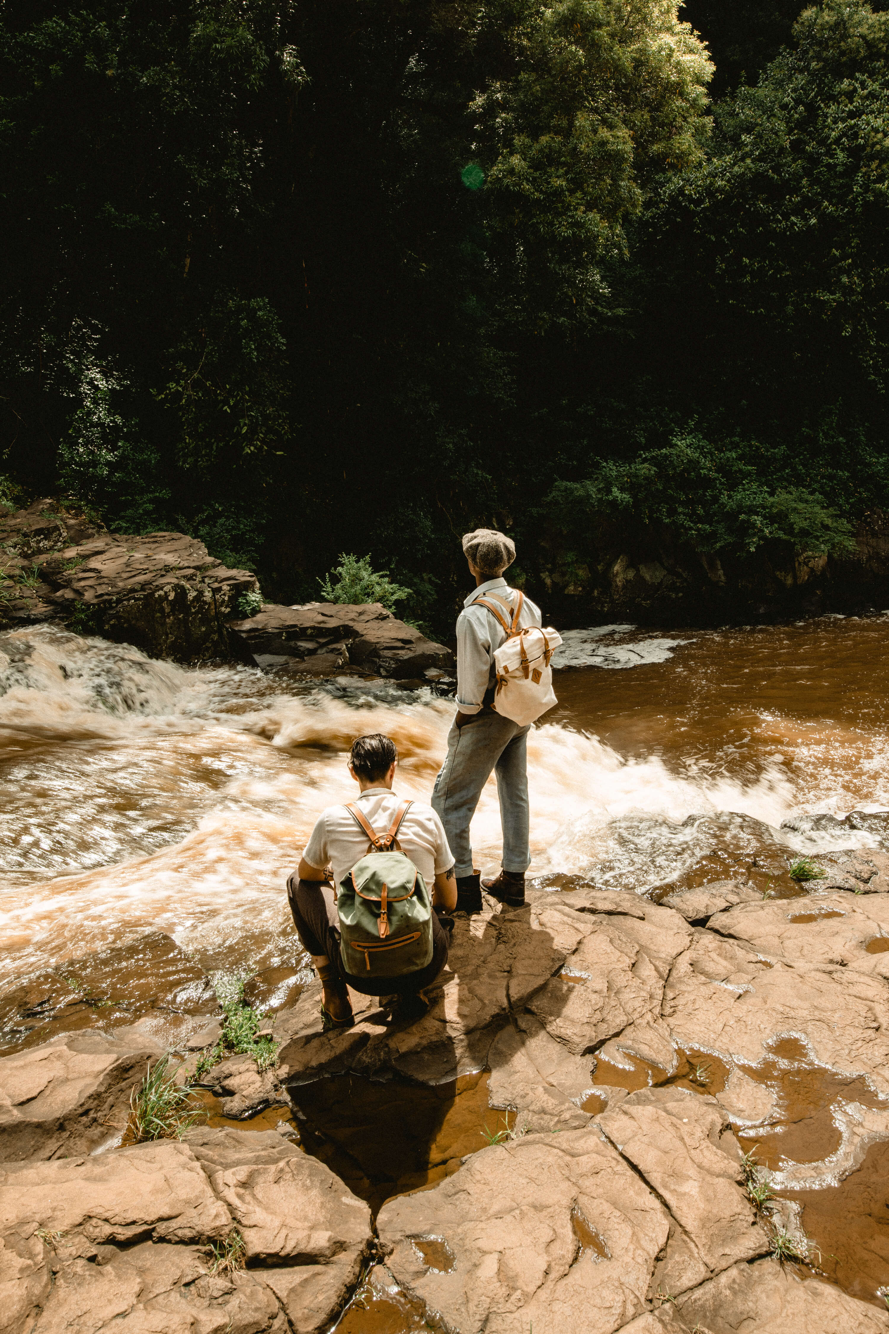 Deux hommes avec des sacs a dos au bord d'une riviere