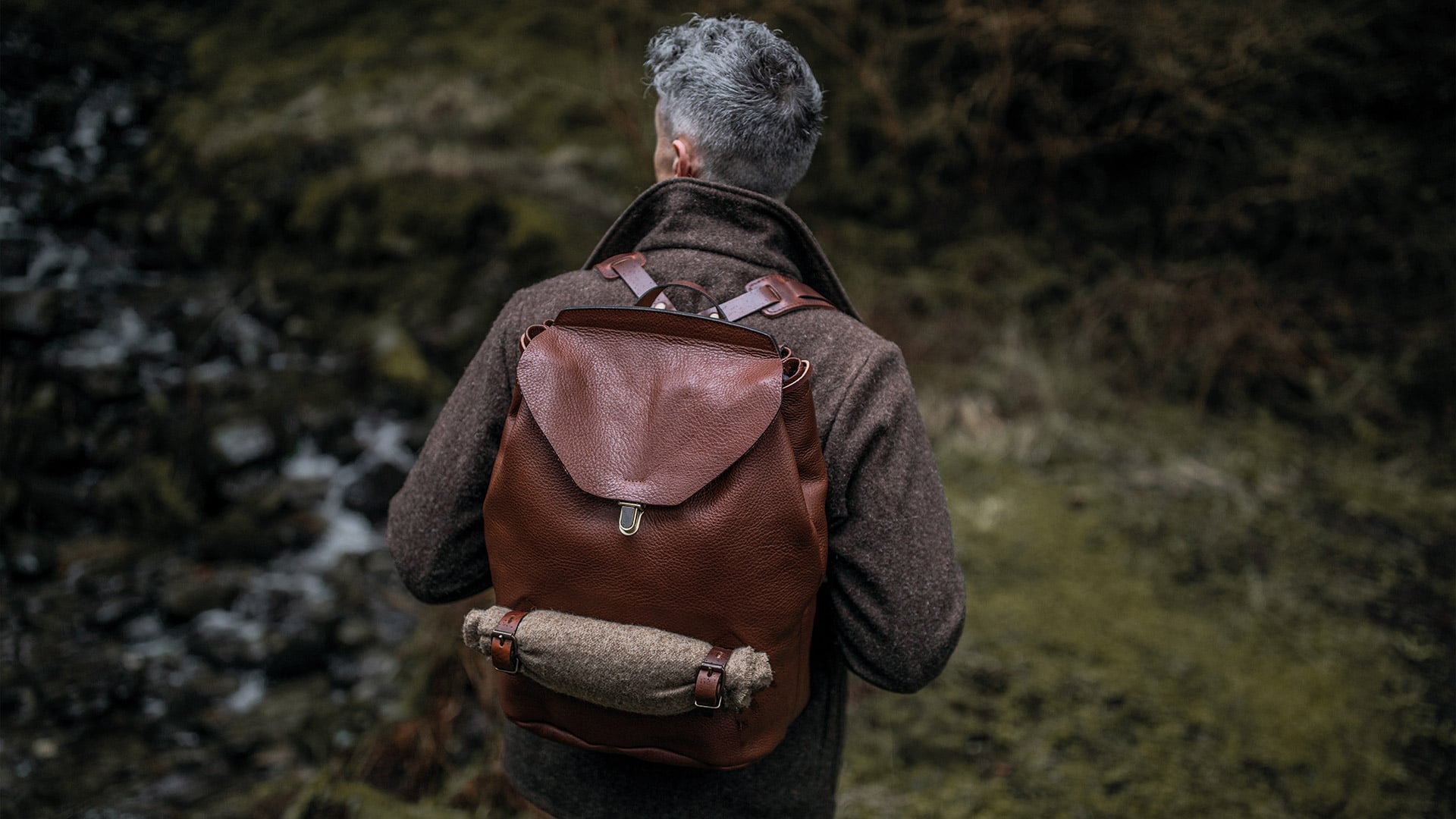 Un hombre en el bosque lleva una mochila de cuero de marta cibelina. 