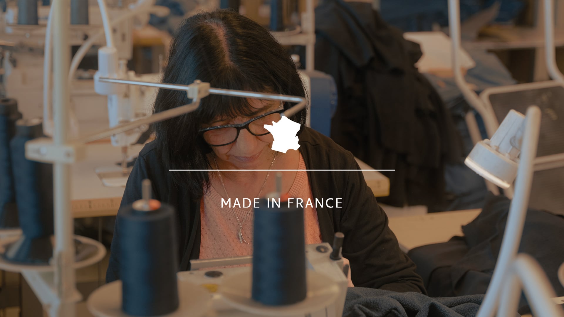 Ein Handwerker n&auml;ht das Sweatshirt von Bleu de Chauffe zusammen.