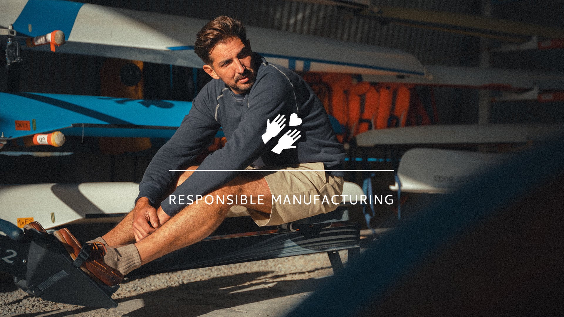 Ein sitzender Mann tr&auml;gt das in Frankreich hergestellte Sweatshirt von Bleu de Chauffe