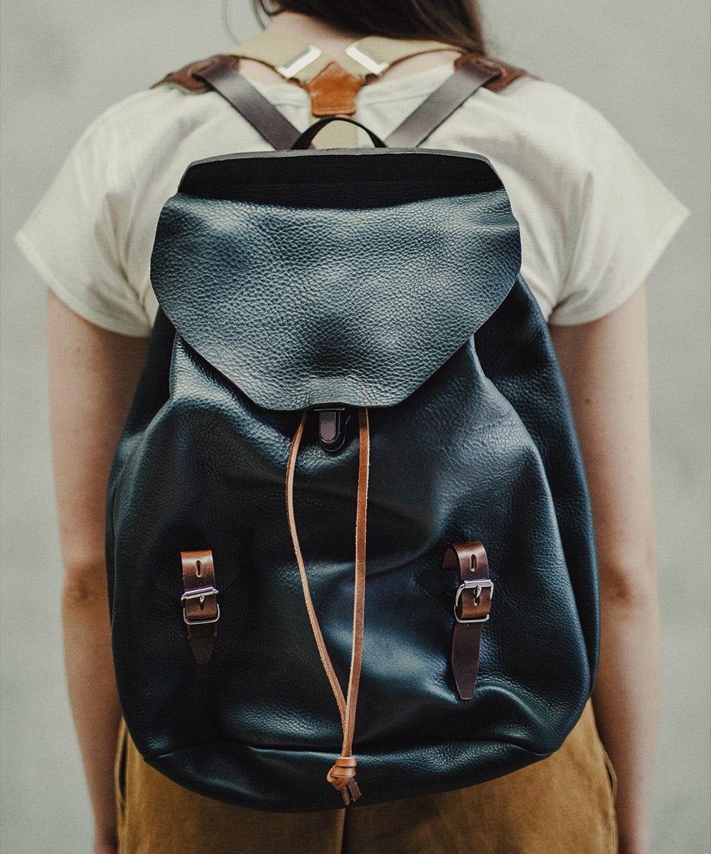 Une femme porte un sac a dos en cuir bleu