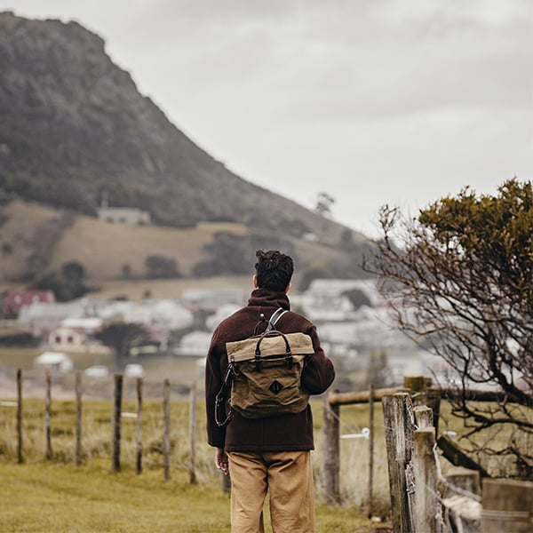 Un hombre en la naturaleza lleva una mochila de trabajo.