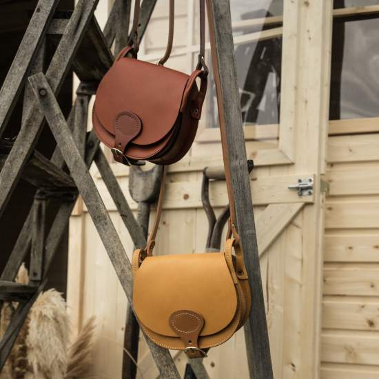 Deux sacs femme en cuir sur un escabot en bois 
