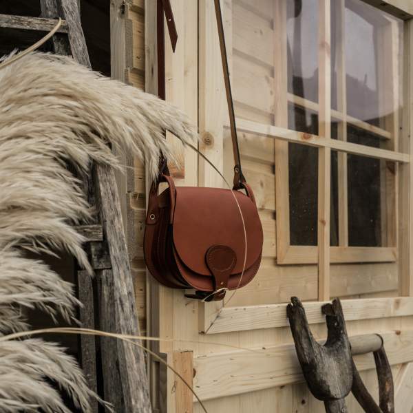 Sac en cuir rouge sur une facade en bois