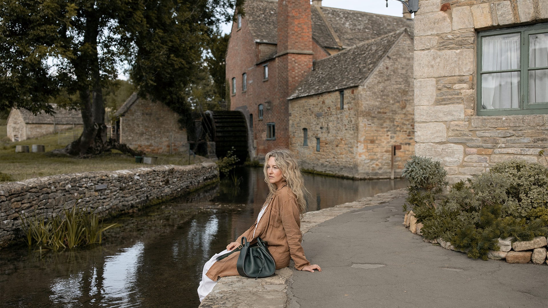 Green bucket bag next to a woman in a small village